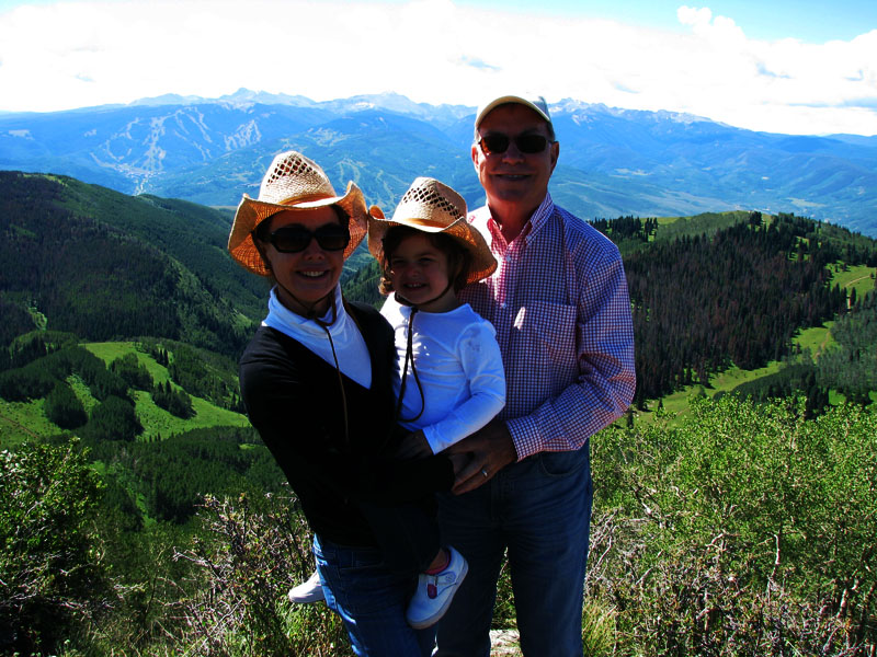 A happy smiling family in front of the mountains and trees